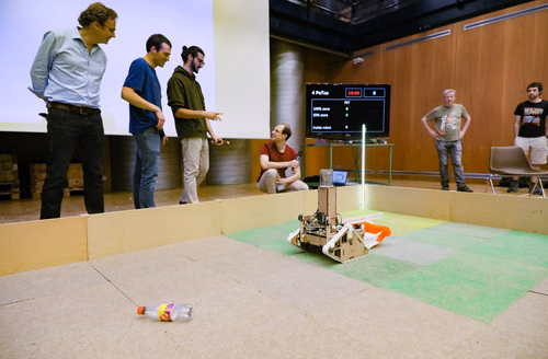 During the STI robot competition, five teams of three master students from different sections of the STI faculty have to design, build and program a cleaning robot. The realized robots must be able to autonomously move in a 64 m² arena that features obstacles and different terrains, while detecting and gathering empty PET bottles, which should then be brought to a specific recycling area. The competition is implemented as a regular semester project during the spring semester.