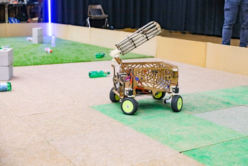 During the STI robot competition, five teams of three master students from different sections of the STI faculty have to design, build and program a cleaning robot. The realized robots must be able to autonomously move in a 64 m² arena that features obstacles and different terrains, while detecting and gathering empty PET bottles, which should then be brought to a specific recycling area. The competition is implemented as a regular semester project during the spring semester.
