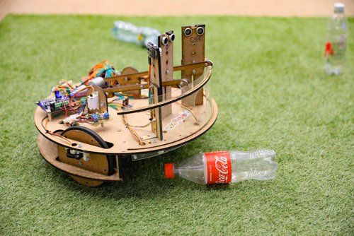 During the STI robot competition, five teams of three master students from different sections of the STI faculty have to design, build and program a cleaning robot. The realized robots must be able to autonomously move in a 64 m² arena that features obstacles and different terrains, while detecting and gathering empty PET bottles, which should then be brought to a specific recycling area. The competition is implemented as a regular semester project during the spring semester.