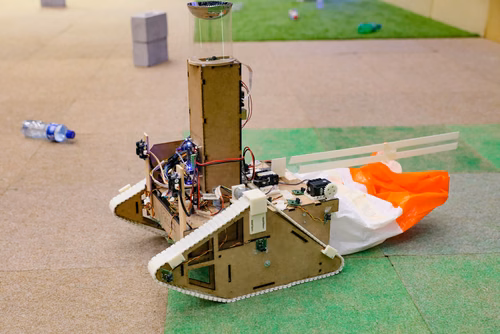During the STI robot competition, five teams of three master students from different sections of the STI faculty have to design, build and program a cleaning robot. The realized robots must be able to autonomously move in a 64 m² arena that features obstacles and different terrains, while detecting and gathering empty PET bottles, which should then be brought to a specific recycling area. The competition is implemented as a regular semester project during the spring semester.