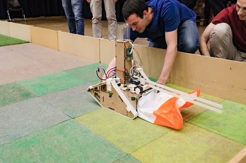 During the STI robot competition, five teams of three master students from different sections of the STI faculty have to design, build and program a cleaning robot. The realized robots must be able to autonomously move in a 64 m² arena that features obstacles and different terrains, while detecting and gathering empty PET bottles, which should then be brought to a specific recycling area. The competition is implemented as a regular semester project during the spring semester.