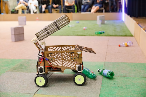 During the STI robot competition, five teams of three master students from different sections of the STI faculty have to design, build and program a cleaning robot. The realized robots must be able to autonomously move in a 64 m² arena that features obstacles and different terrains, while detecting and gathering empty PET bottles, which should then be brought to a specific recycling area. The competition is implemented as a regular semester project during the spring semester.