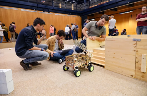 During the STI robot competition, five teams of three master students from different sections of the STI faculty have to design, build and program a cleaning robot. The realized robots must be able to autonomously move in a 64 m² arena that features obstacles and different terrains, while detecting and gathering empty PET bottles, which should then be brought to a specific recycling area. The competition is implemented as a regular semester project during the spring semester.