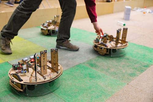 During the STI robot competition, five teams of three master students from different sections of the STI faculty have to design, build and program a cleaning robot. The realized robots must be able to autonomously move in a 64 m² arena that features obstacles and different terrains, while detecting and gathering empty PET bottles, which should then be brought to a specific recycling area. The competition is implemented as a regular semester project during the spring semester.